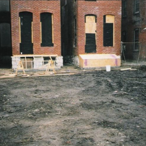 The restored Scott Joplin House brickwork after reconstruction, with the rebuilt walls and openings standing sound on a cleared site
