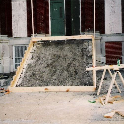 A school entrance with the old stairs demolished back to fill and timber formwork set for the new pour